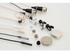This is a photo of all four colours of the Sanken COS-11D R/RM microphone. Black, grey, white and beige. In the picture it's shown with two connectors as well. Also shown with accessories including microphone clips and microphone wind protectors
